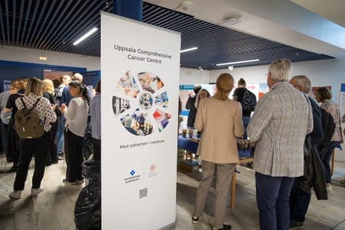 Många personer som står upp och minglar i utställningslokal